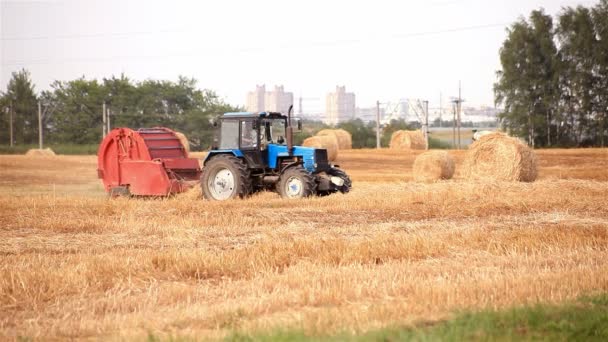 収穫機。トラクターが藁の俵 — ストック動画