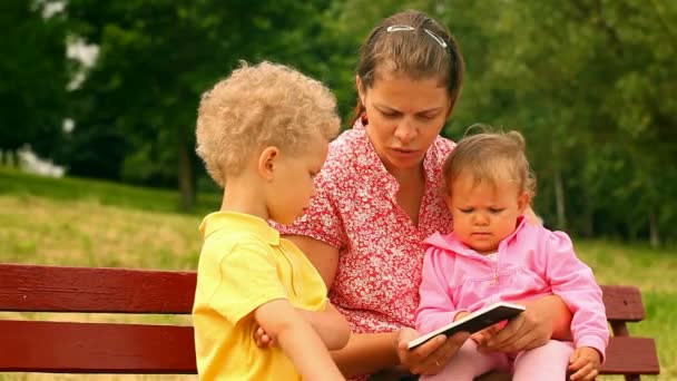 Moeder en twee kinderen, lezen en kijken naar Tablet PC 's — Stockvideo