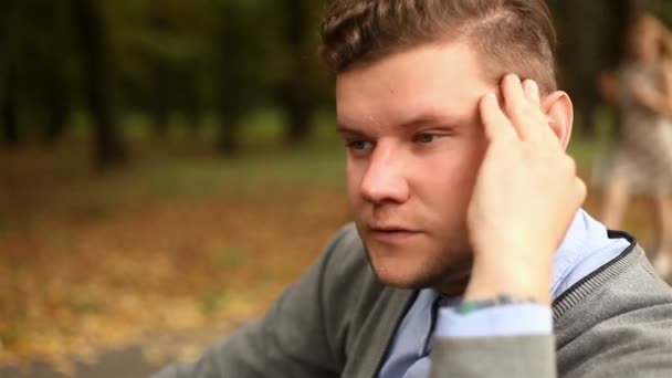 郁闷、 悲伤的年轻商人坐在公园里 — 图库视频影像