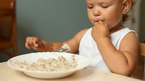 Liten flicka äter gröt — Stockvideo