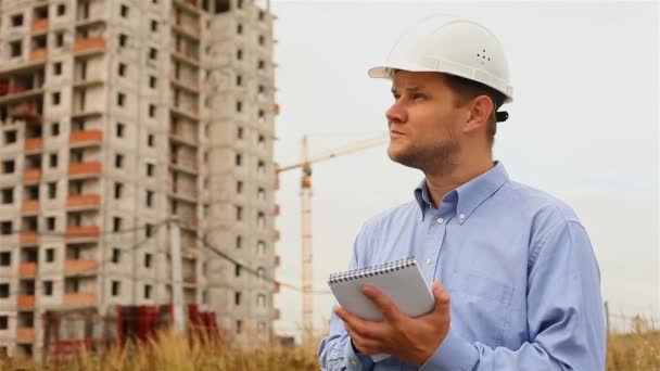 Ingeniero de construcción escribe en un cuaderno — Vídeo de stock