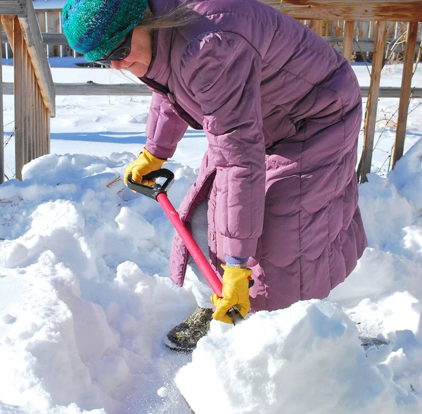 Female shoveling snow. — Stock Photo, Image