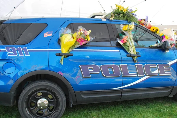 車の外のパトロール車の花で義務の行で死亡した警察官のための記念碑 — ストック写真