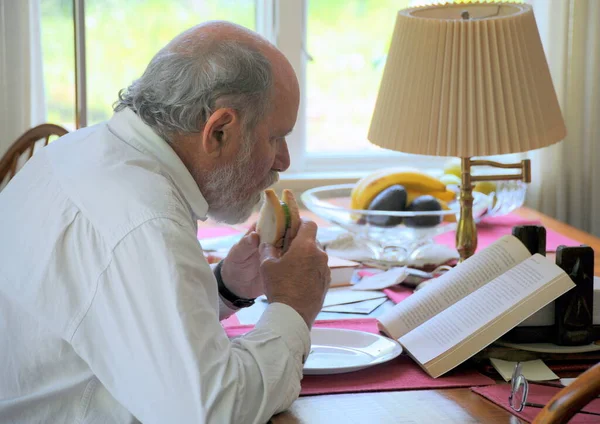 Hombre Maduro Mayor Comiendo Sándwich Leyendo Libro Casa — Foto de Stock