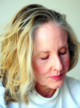 Olgun sarışın kadın, ofisinde fazla mesai yapıyor..