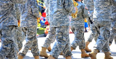 Army band marching in a parade outside.