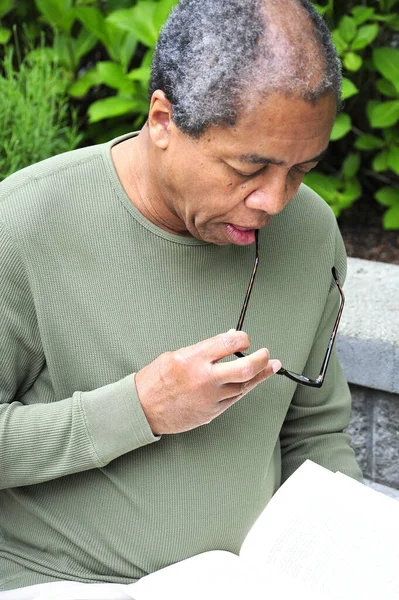 Hombre Afroamericano Senior Leyendo Libro Afuera —  Fotos de Stock