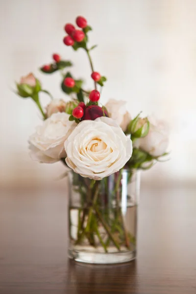 Rosas y bayas rojas en un vaso —  Fotos de Stock