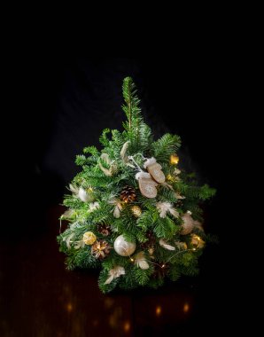 Doğal dallardan yapılmış Noel ağacı ve ahşap bir masa üzerinde Noel topları