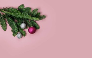 Pembe arka planda ladin ve noel baloları