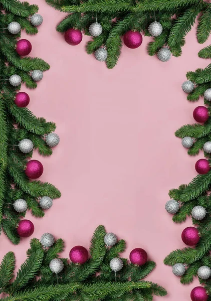 ピンクの背景にフレームとしてクリスマスツリーとボール ロイヤリティフリーのストック写真