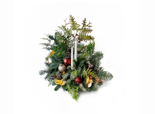 白底上有新鲜云杉枝干 圣诞装饰品 松果和干柑橘片的桌上配料 图库图片