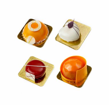 Beyaz arkaplanda dört kremalı pasta seti