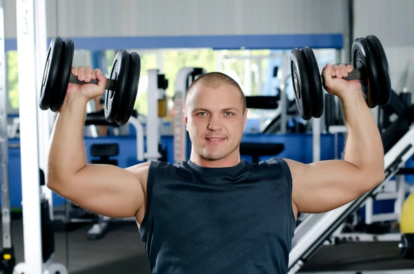 Man with dumbbells in sports club — Stock Photo, Image