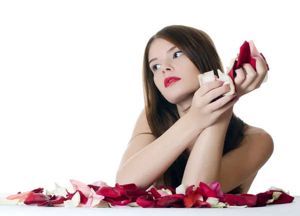 Den vackra flickan med kronblad av rosor isolerade — Stockfoto