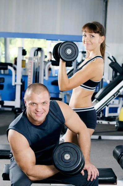 Homme et femme avec haltères dans le club de sport — Photo