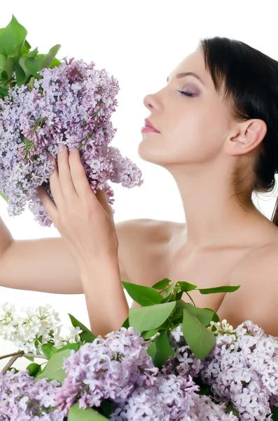 Vacker kvinna med vårblommor i en lila. hudvård — Stockfoto