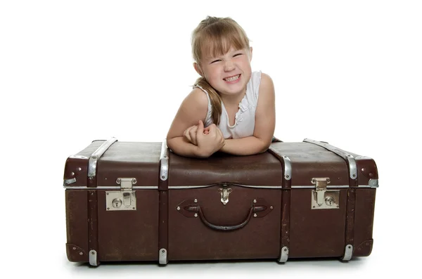 Маленькая девочка на старых чемоданах — стоковое фото