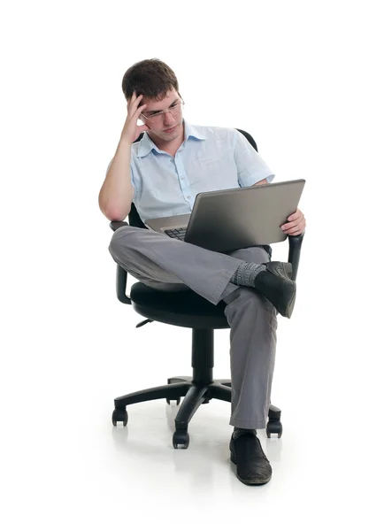 The businessman sits in an armchair with laptop Stock Photo