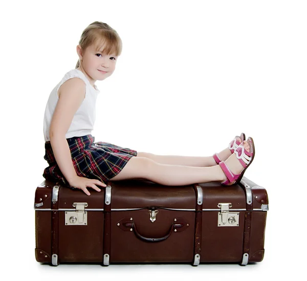 Das kleine Mädchen auf alten Koffern — Stockfoto