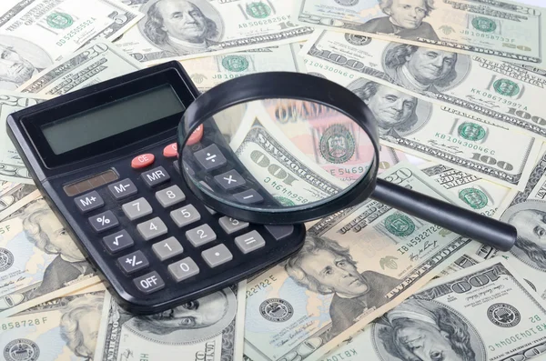 The magnifying glass lying on banknotes — Stock Photo, Image