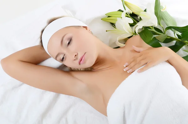 Spa Woman lays with a white lily — Stock Photo, Image