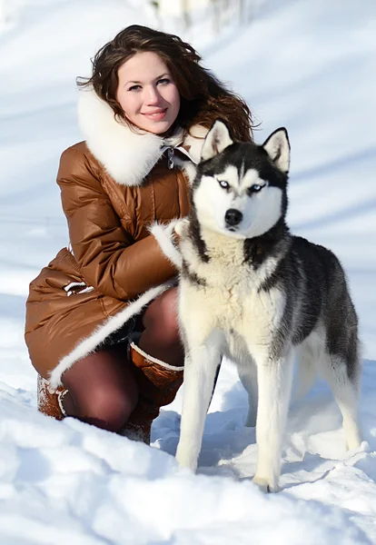 Kvinnan med en hund som husky på vintern — Stockfoto