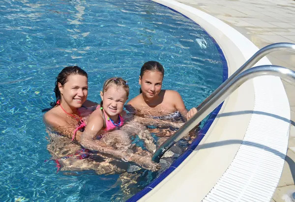 Smiling beautiful woman and her daughter have a fun in pool outdoor — Stock Photo, Image