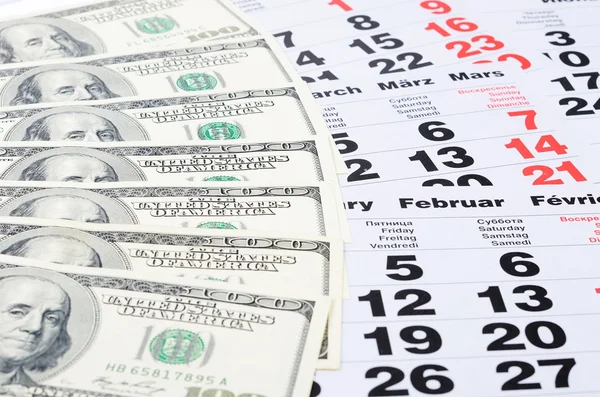 Bankbiljetten van dollars op kalenderbladen close-up — Stockfoto