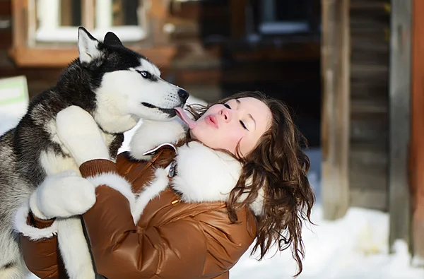 Женщина с собакой Хаски зимой — стоковое фото