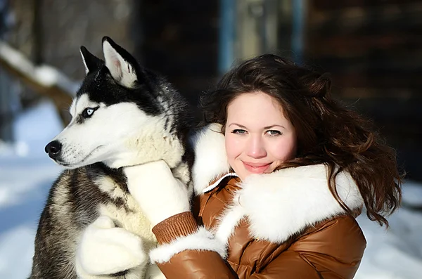 La donna con un cane Husky nell'inverno — Foto Stock