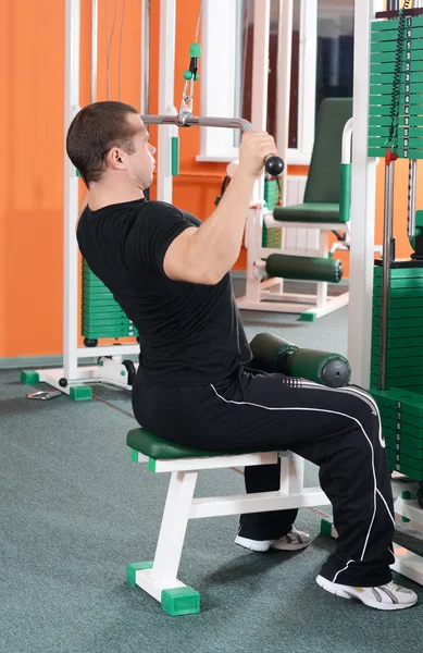 The man on training apparatus in sports club — Stock Photo, Image