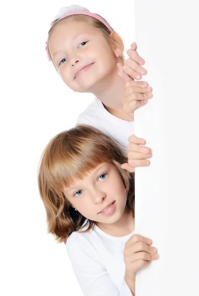 Kleines Mädchen guckt hinter der Werbung hervor — Stockfoto