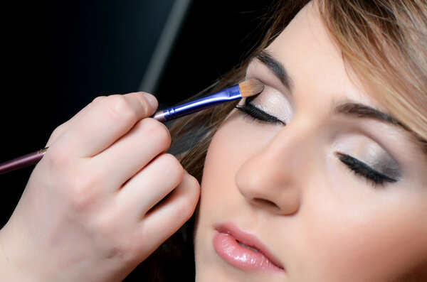 beautiful girl put the makeup on the face