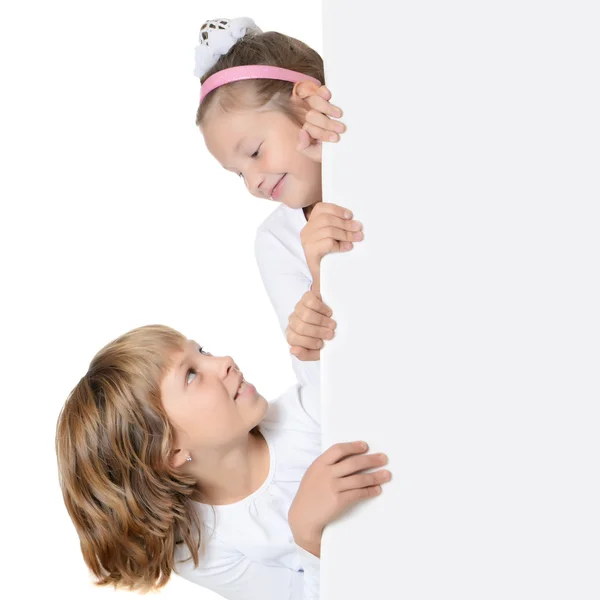 Kleines Mädchen guckt hinter der Werbung hervor — Stockfoto