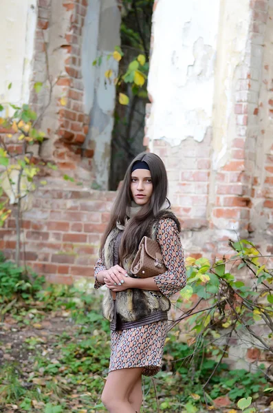 Девушка осенью у разрушенного старого здания — стоковое фото