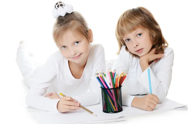 Iki kız beyaz izole renkli kalemler çizmek — Stok fotoğraf