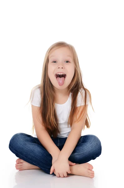 Das kleine Mädchen streckt die Zunge aus — Stockfoto