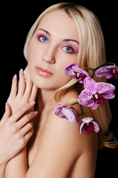 The beautiful young woman with flowers of orchid Royalty Free Stock Photos