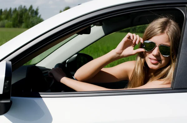 Het mooie meisje op het wiel de witte auto — Stockfoto