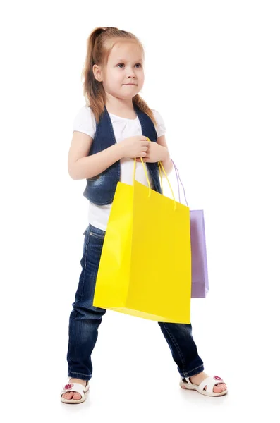 Het kleine meisje met twee pakketten geïsoleerd — Stockfoto