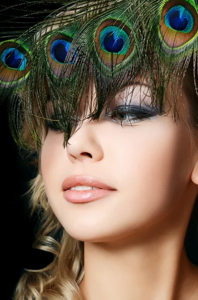 The beautiful woman with feathers of a peacock — Stock Photo, Image