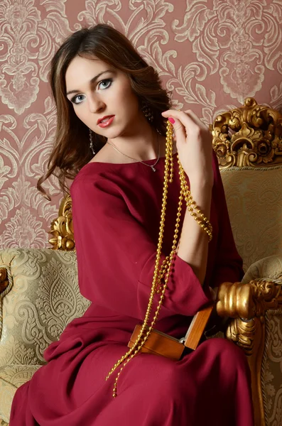 The elegant sensual young woman in a claret dress — Stock Photo, Image