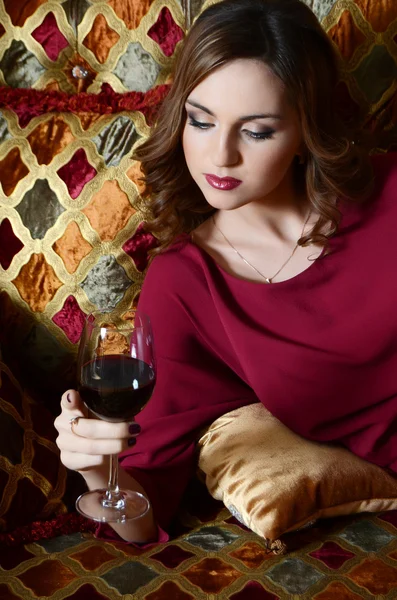 Zmysłowe kobiety przy lampce czerwonego wina na wspaniałą sofę — Zdjęcie stockowe