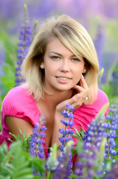 The beautiful woman in the field with lupin — Stock Photo, Image