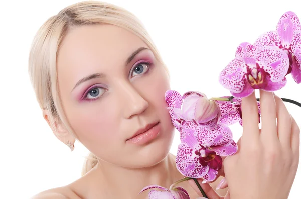 Den vackra unga kvinnan med blommor av orkidé — Stockfoto