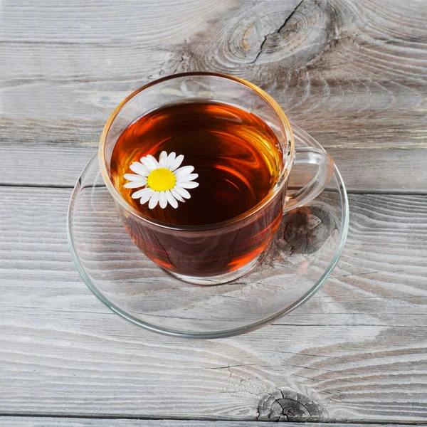 Copa de vidrio con un té de manzanilla — Foto de Stock