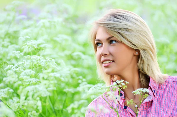 Die schöne Frau auf dem Feld mit Blume — Stockfoto