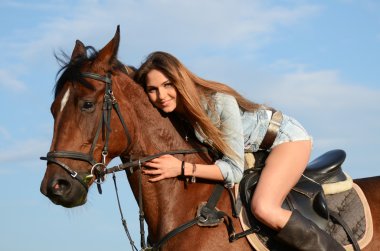 la mujer de un caballo contra el cielo