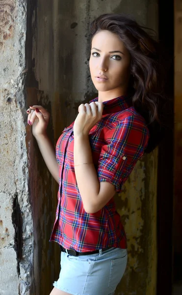 The woman against the destroyed old wall — Stockfoto